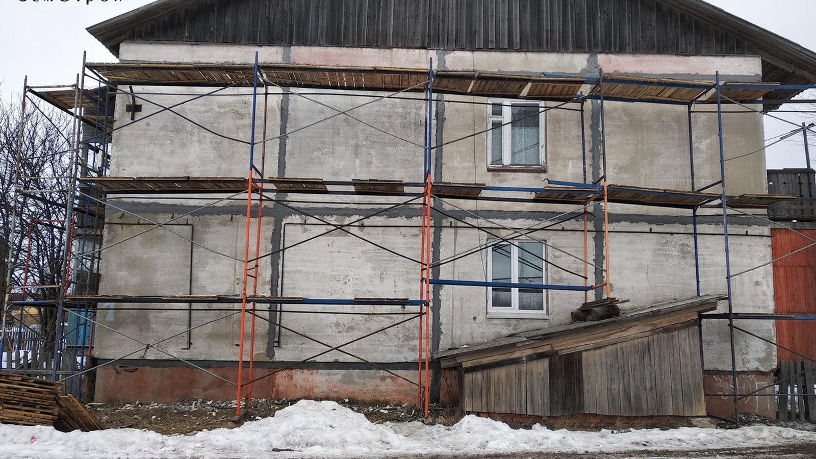 Фасад жилого дома в строительных лесах во время капитального ремонта